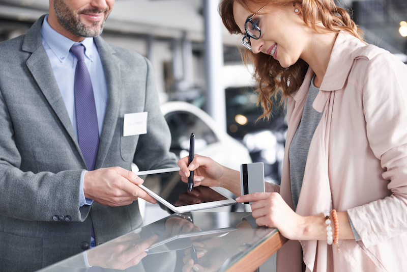 Salesman dealer using digital tablet to sign in