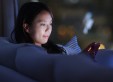 woman sitting on couch using phone